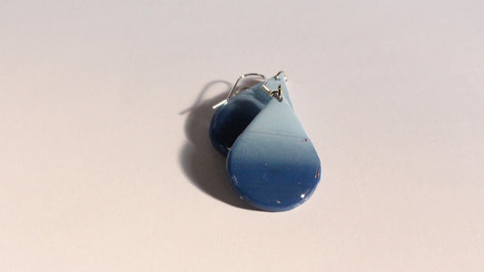 Blue teardrop-shaped earrings on a light beige background