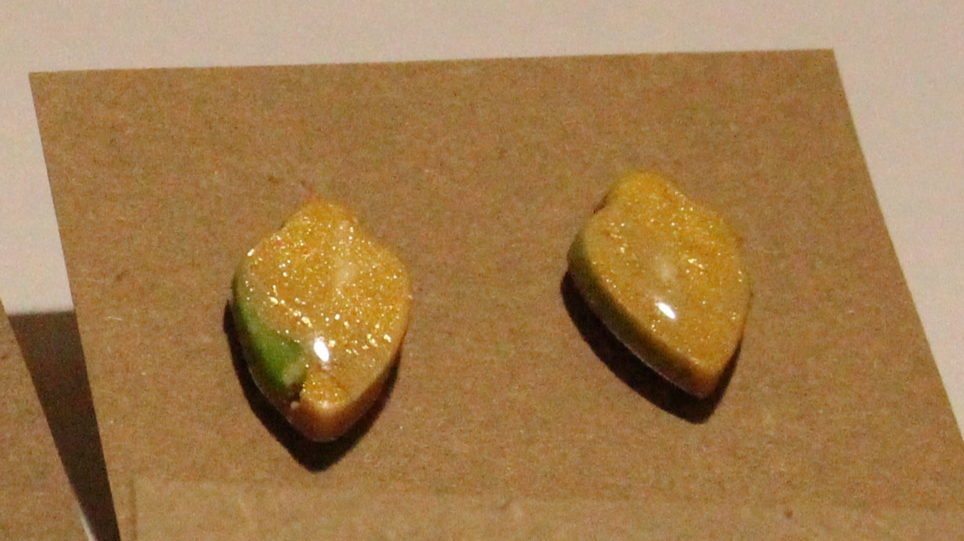 Assorted earrings on brown card backing displayed on a flat surface.