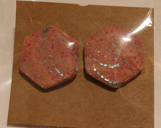 Two red stone earrings on a brown card with clear plastic cover