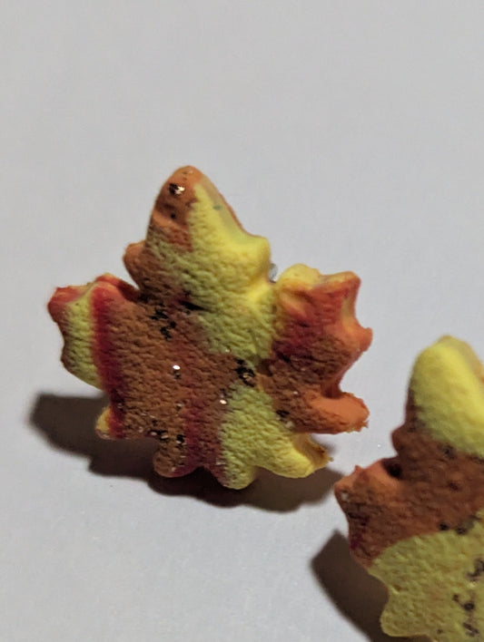 Pair of leaf-shaped earrings on a light gray background